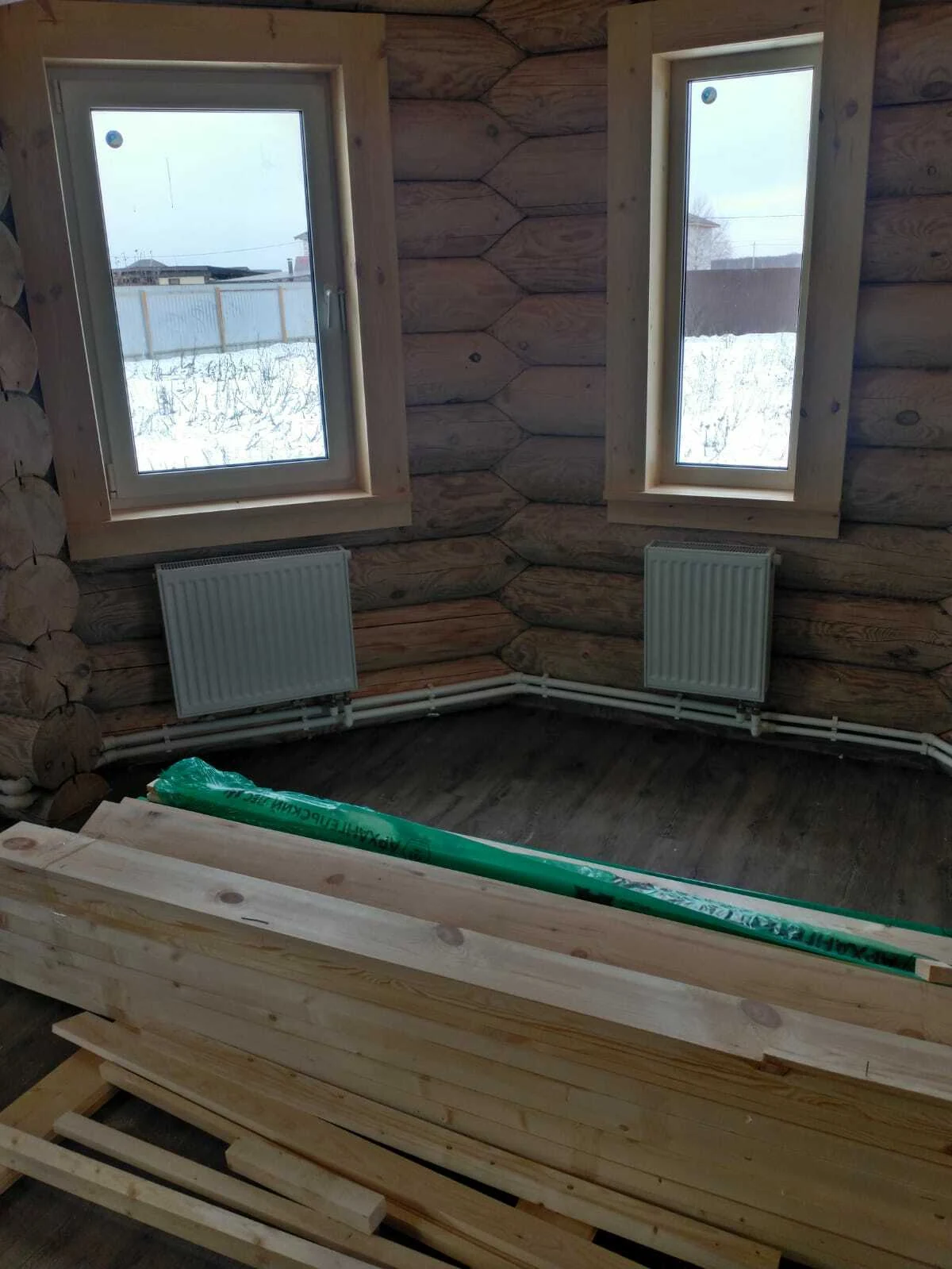 Установленные окна в деревянном доме во время отделки